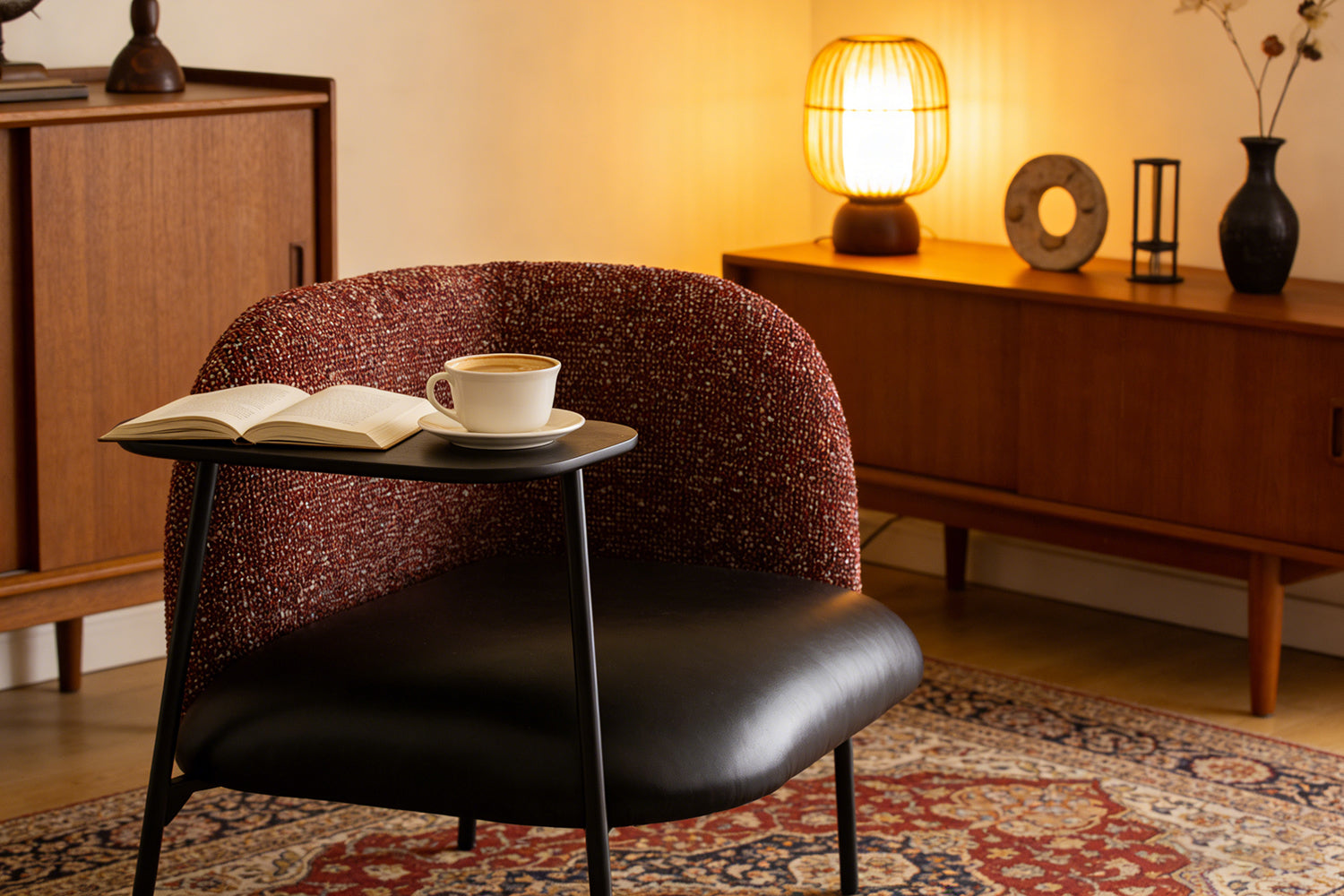 Side view of the Angela Armchair showcasing its elegant curved silhouette, integrated side table, and slim black metal legs