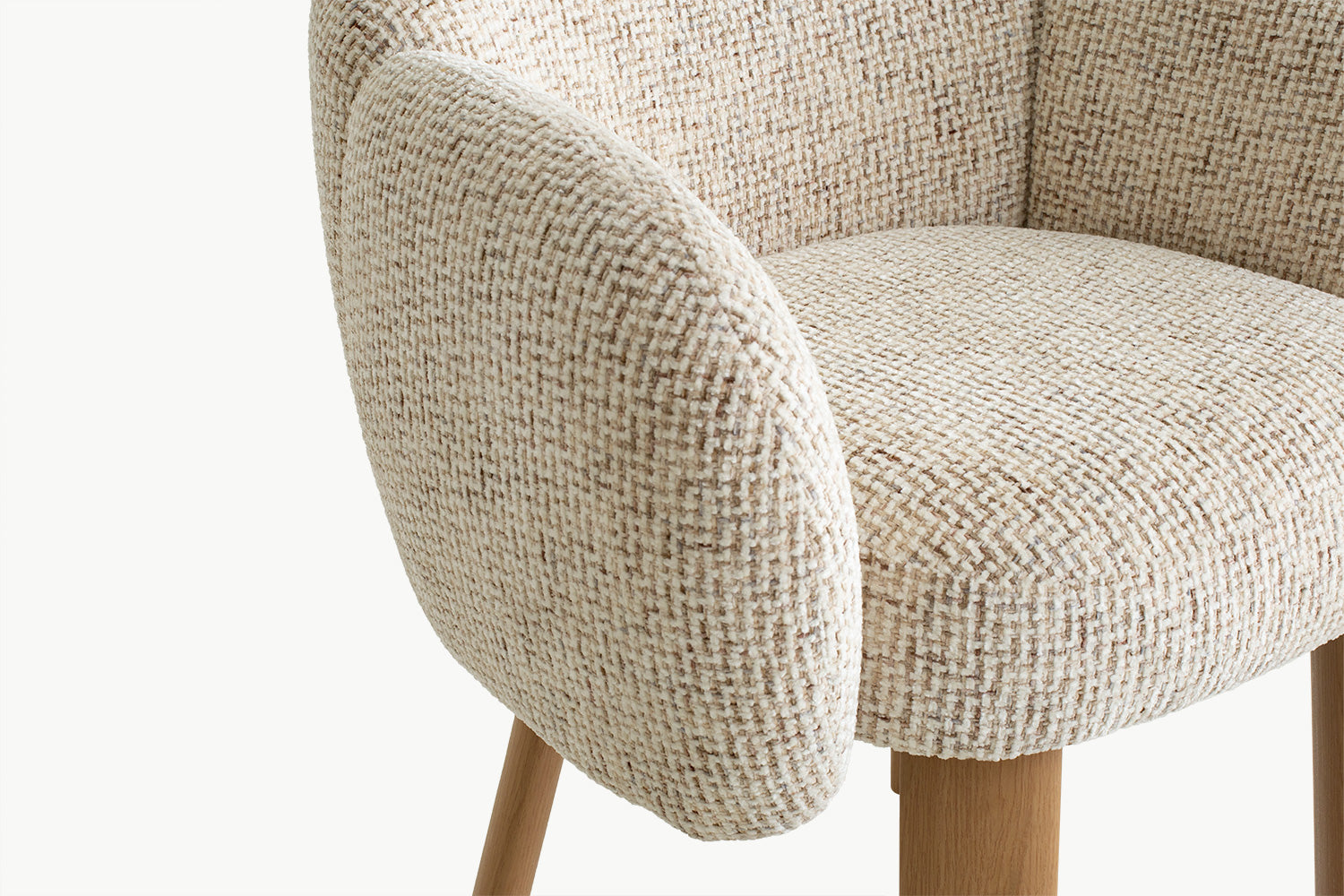 Detail close-up kain bouclé mewah pada kursi makan Anna dan sandaran lengan yang melengkung halus, menonjolkan material premium serta kenyamanan berkelas yang menjadi ciri khas furnitur ini.