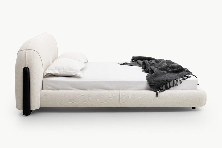 Detailed view of Chirs Bed's black vertical side panels contrasting the soft beige fabric, highlighting sturdy construction and modern geometric touch