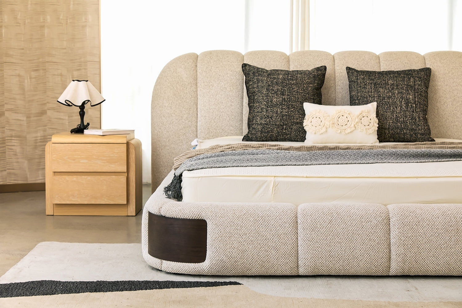 Detailed view of Chloe Bed's scalloped headboard with vertical channel tufting in premium beige boucle fabric, highlighting soft texture and elegant curvature