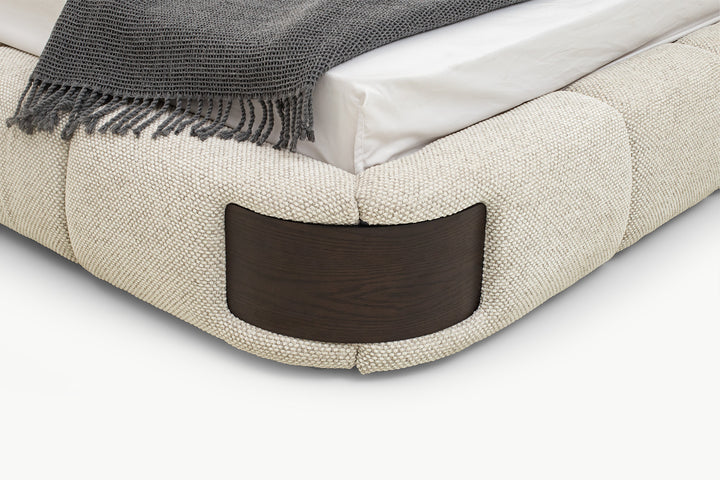 Elegant Bedroom Bed close-up of rounded corner cushioning and rich walnut wood panel inset, showcasing seamless integration and premium material contrast