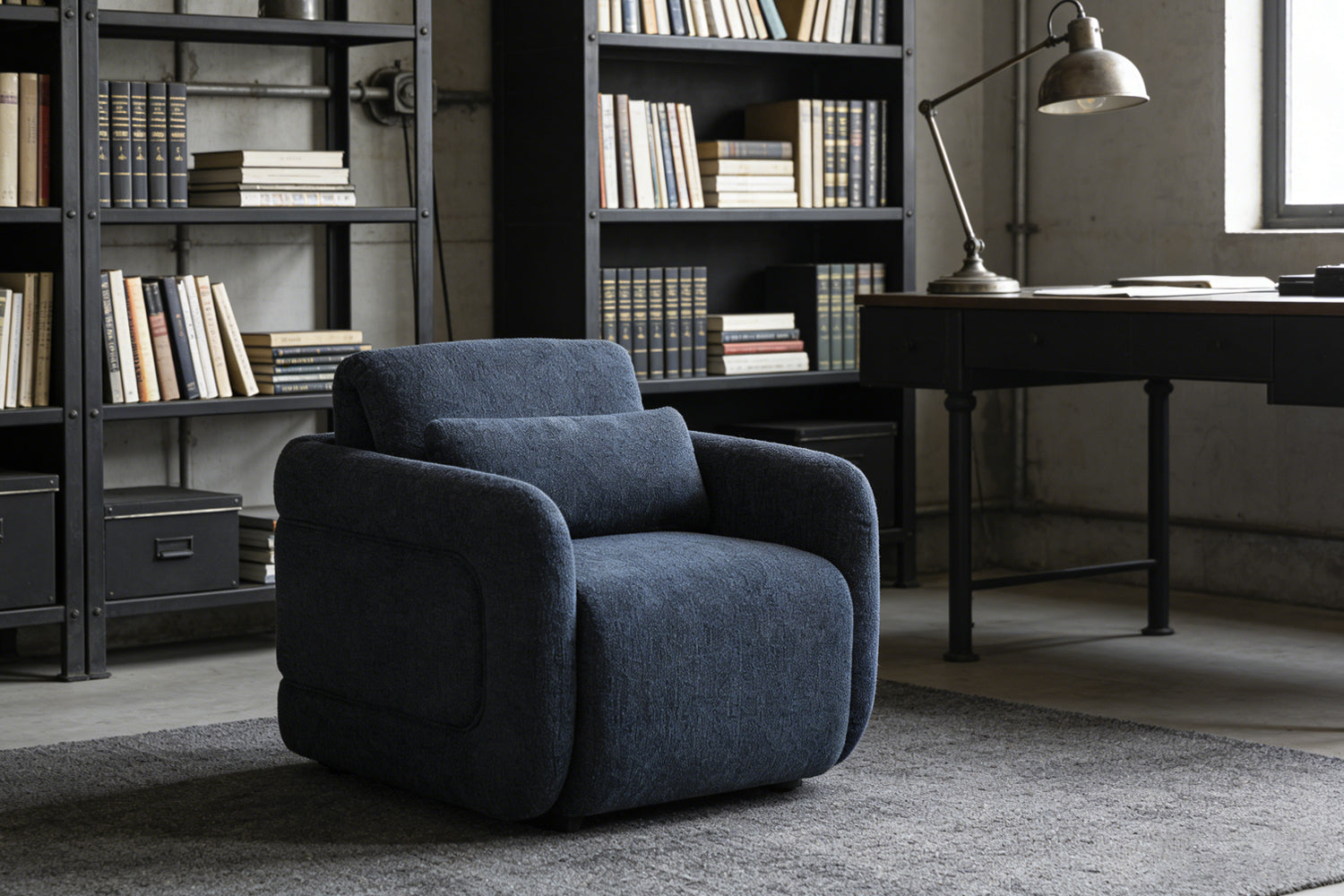 Cozy dark blue armchair in an industrial-style study with bookshelves, offering a comfortable spot for reading and relaxation