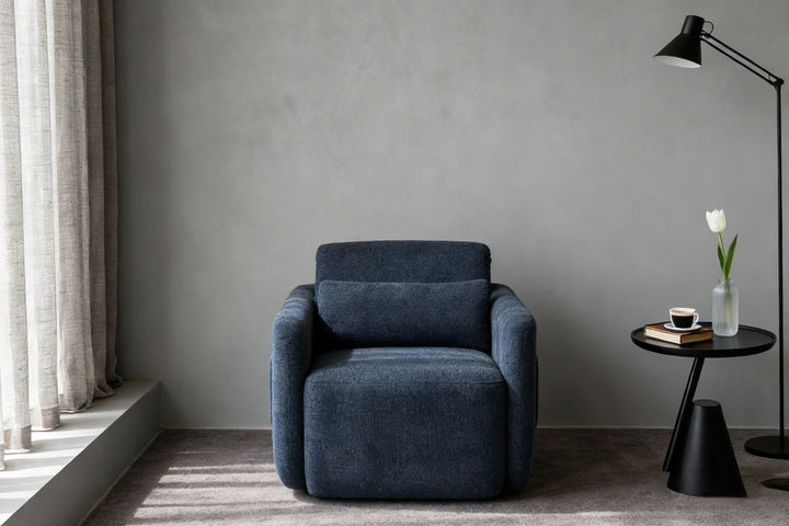 Sleek navy blue leisure chair against a neutral gray wall, perfect for contemporary minimalist interiors with its soft curved silhouette