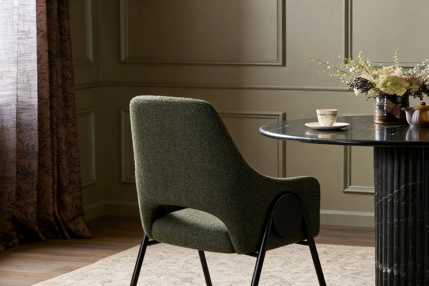 Rear perspective of the olive dining chair emphasizing the high, supportive backrest in deep olive boucle fabric and sturdy black metal frame, ideal for comfortable extended seating.