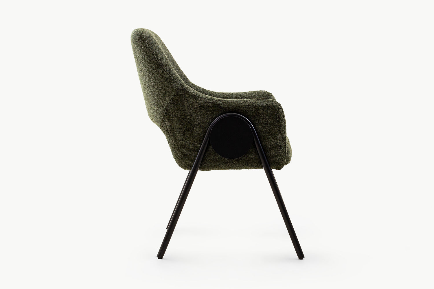 Side view of the olive dining chair highlighting its sculptural curved form, plush textured fabric, black metal splayed legs, and unique circular black accent for added contemporary flair.